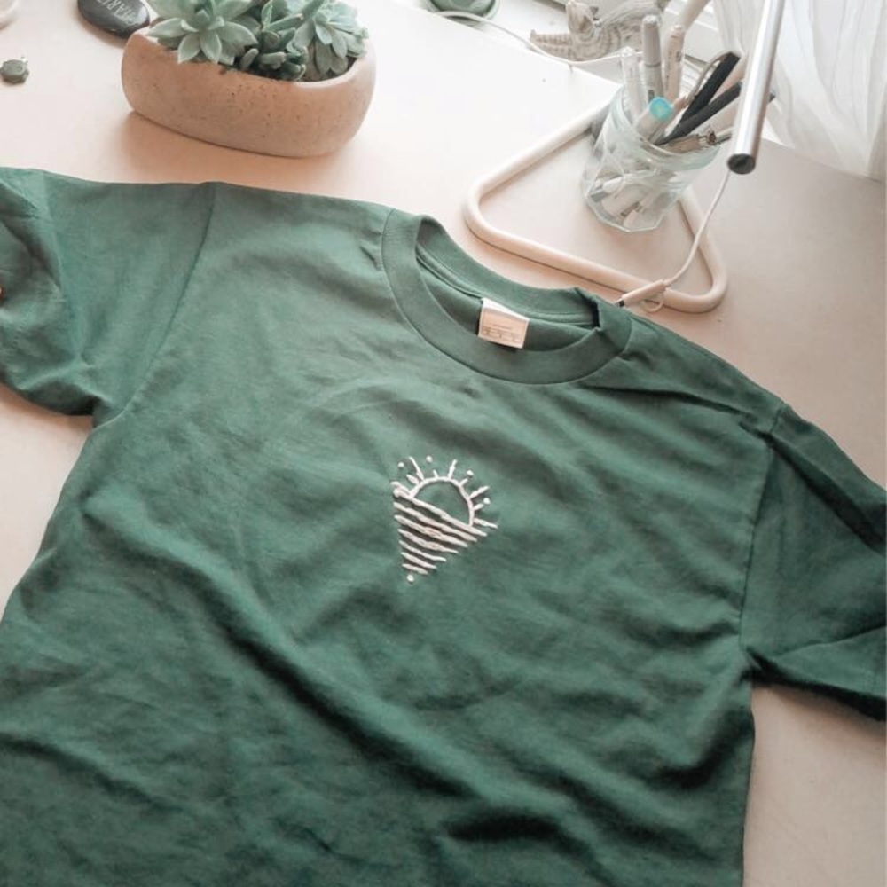 Costumed dark green shirt with embroidered sun